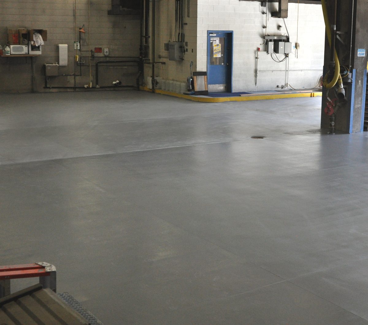 Repaired and coated gray floor in a road maintenance shop